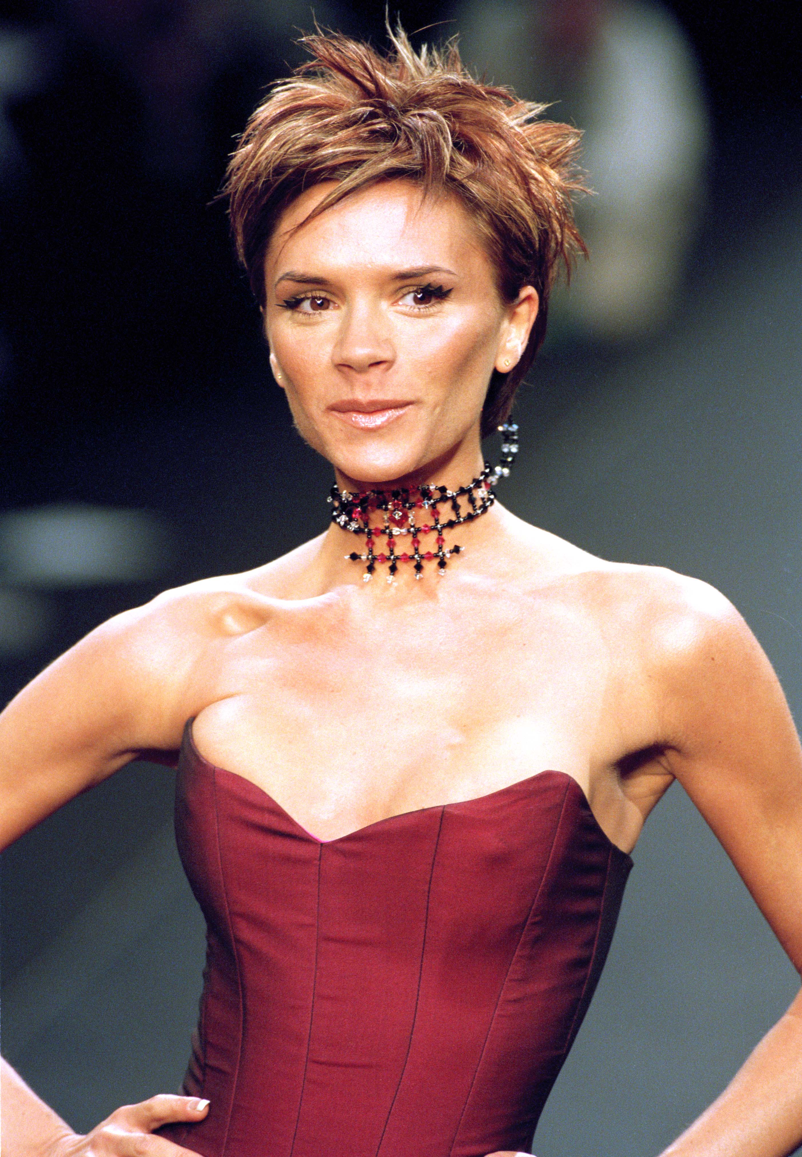 A woman with a Victoria-Beckham-haircut and a black top, crossing her arms  and grinning Stock Photo - Alamy
