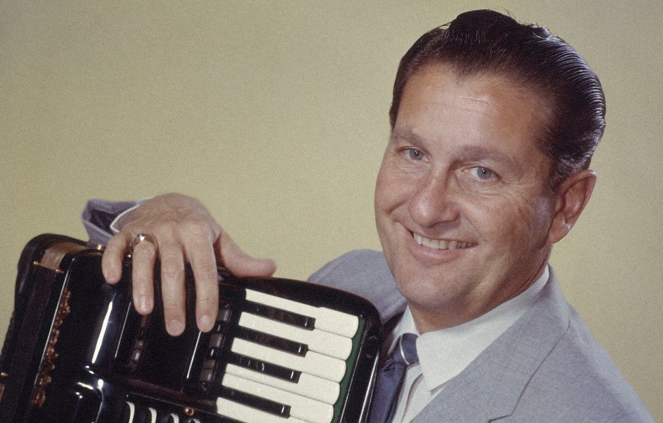 Lawrence Welk (1903-1992), US musician and band leader, smiling while posing with an accordian, circa 1955