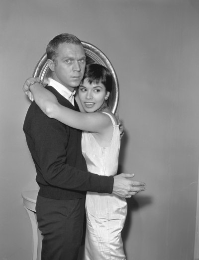 Married American actors Steve McQueen (1930 - 1980) and Neile Adams embrace during the filming of an episode of the television anthology series 'Alfred Hitchcock Presents' entitled 'Man from the South,' 