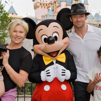 Actor Hugh Jackman, his wife Deborra Lee Furness, and children Oscar Jackman and Ava Jackman pose with Mickey Mouse outside Sleeping Beauty Castle at Disneyland