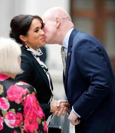 Meghan Markle, Duchess of Sussex kisses Lord Christopher Geidt (former Private Secretary to Queen Elizabeth II) as she arrives to attend a panel discussion, convened by The Queen's Commonwealth Trust, to mark International Women's Day 