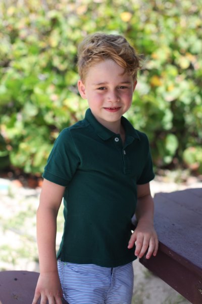 prince george wears green polo shirt and blue and white striped pants in portrait taken by kate middelton