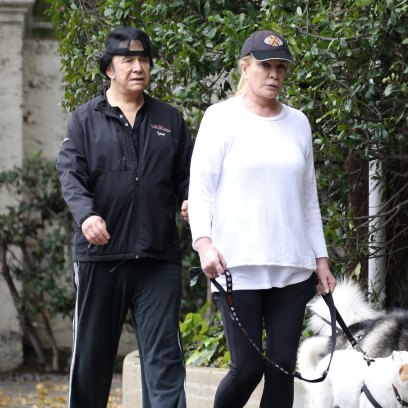 KISS frontman Gene Simmons is seen dressed in a backwards cap, black sweatpants and a matching top as walks his two dogs, George and Baby, with his wife, former Playboy playmate of the year, Shannon Tweed.