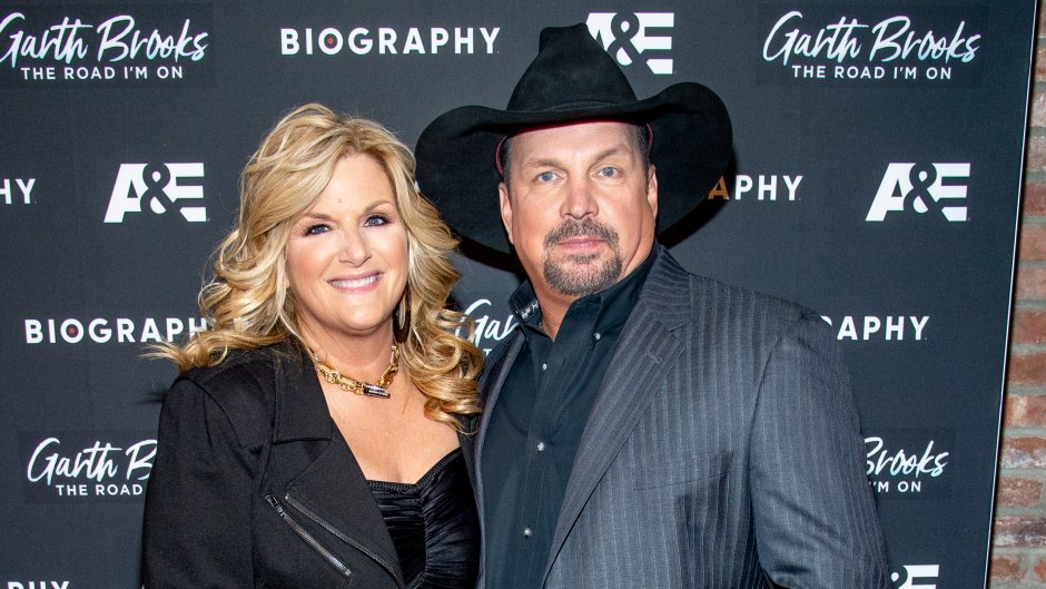 Garth Brooks wears gray suit jacket with blue jeans next to wife Trisha Yearwood