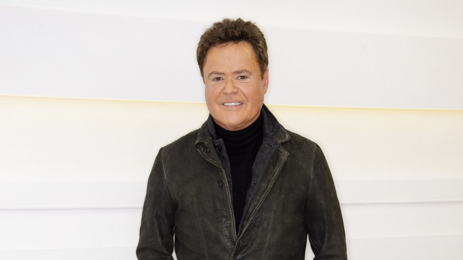 Donny Osmond poses in leather jacket and jeans