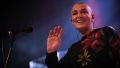 Sinead O'Connor waves and smiles