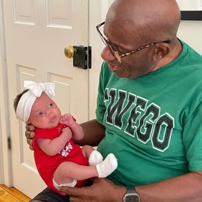 Al Roker holds granddaughter Sky while wearing Oswego T-shirt