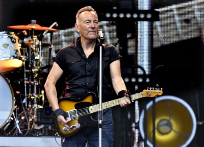 Bruce Springsteen sings and plays guitar in black shirt and jeans
