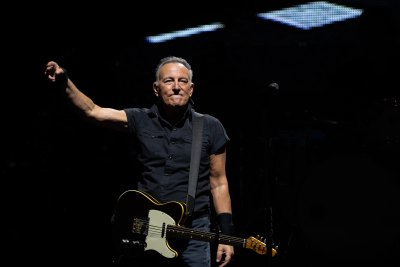 Bruce Springsteen performs in a black button-down shirt and jeans
