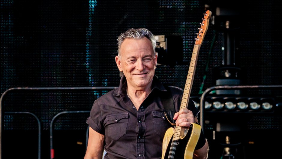 Bruce Springgsteen holds guitar on stage at concert