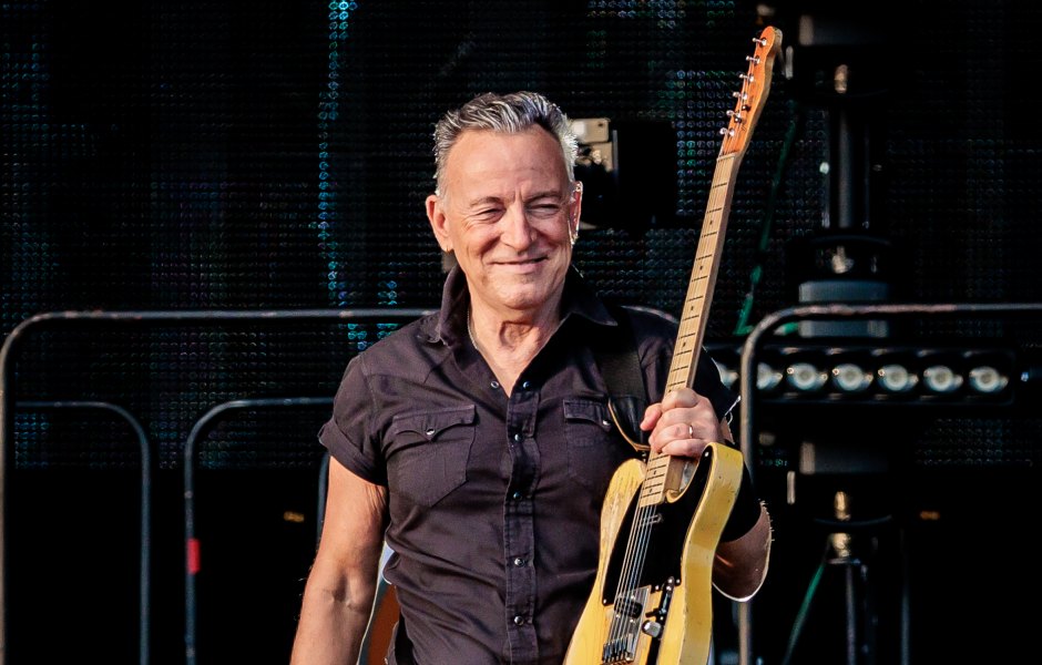 Bruce Springgsteen holds guitar on stage at concert