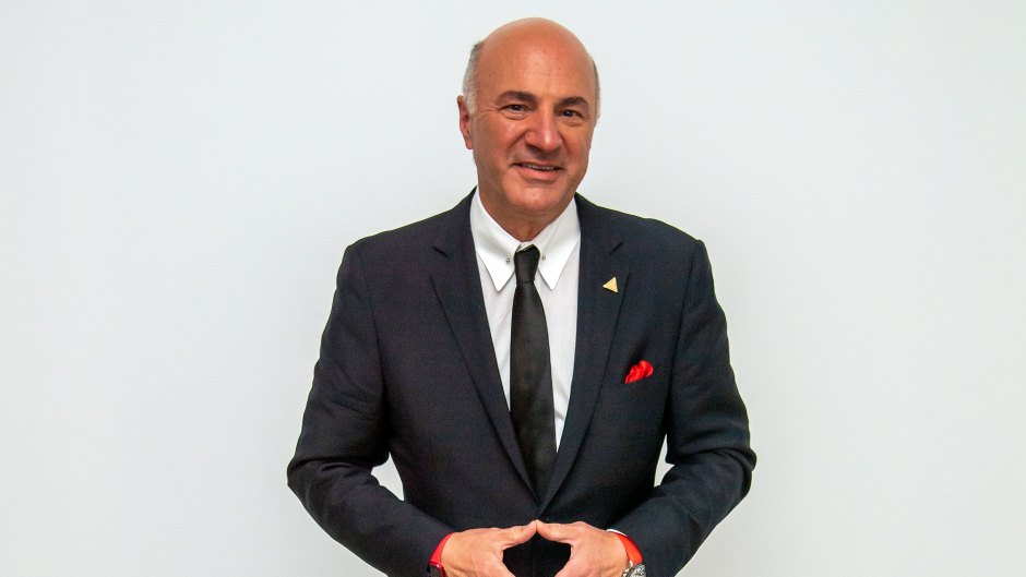 Kevin O'Leary wears black suit with black tie and red handkerchief