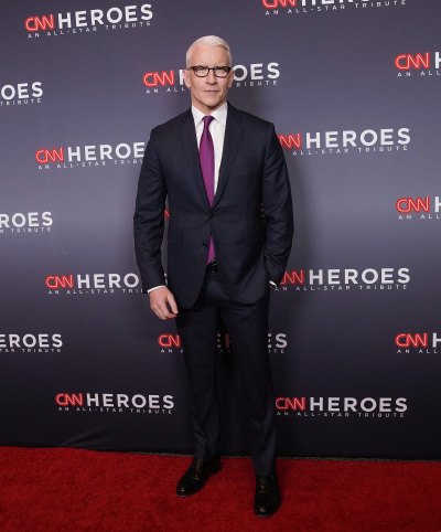 Anderson Cooper wears black suit and red tie