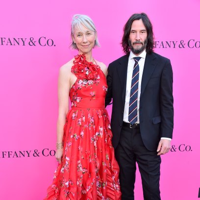 Keanu Reeves wears black suit and girlfriend Alexandra Grant wears red dress