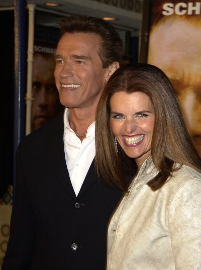 Arnold Schwarzenegger smiles next to Maria Shriver