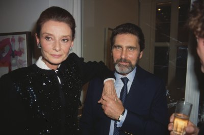 Audrey Hepburn rests hand don shoulder of partner Robert Wolders