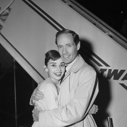 Audrey Hepburn smiles while hugging husband Mel Ferrer