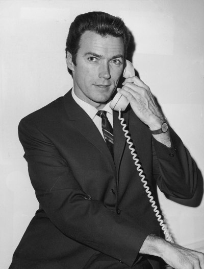 Clint Eastwood answers phone while wearing a suit