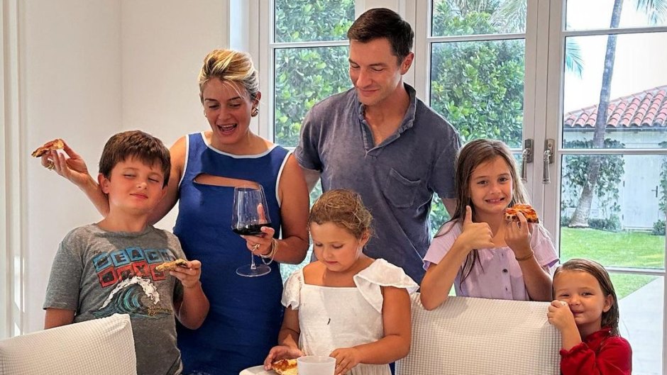 Daphne Oz and husband John Jovanovic stand at kitchen table with their four kids