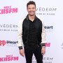 Ryan Seacrest wears black and white bomber jacket with black pants