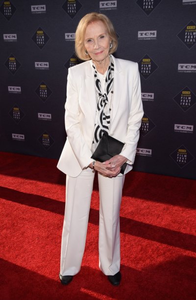 Eva Marie Saint wears white pantsuit and carries black clutch purse