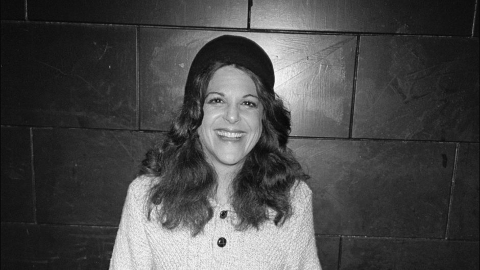 Gilda Radner wears white sweater, jeans and hat