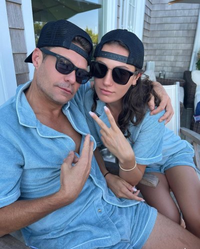 Ryan Seacrest and Aubrey Paige Petcosky wear matching blue outfits with hats and sunglasses