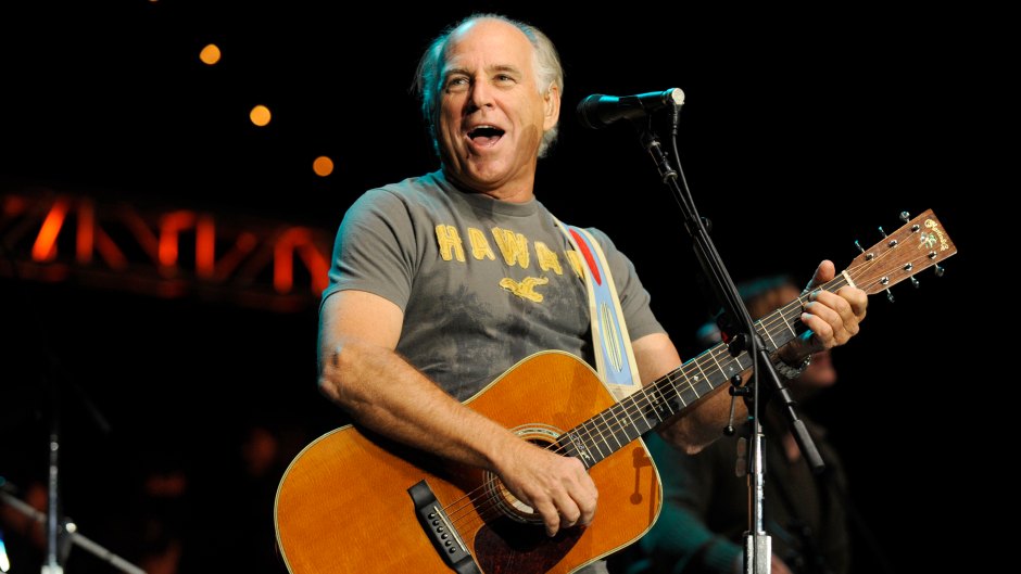 Jimmy Buffett performs with giuitar on stage in T-shirt
