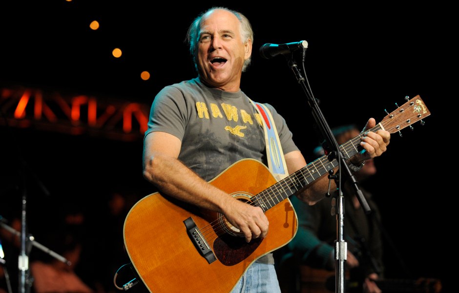 Jimmy Buffett performs with giuitar on stage in T-shirt