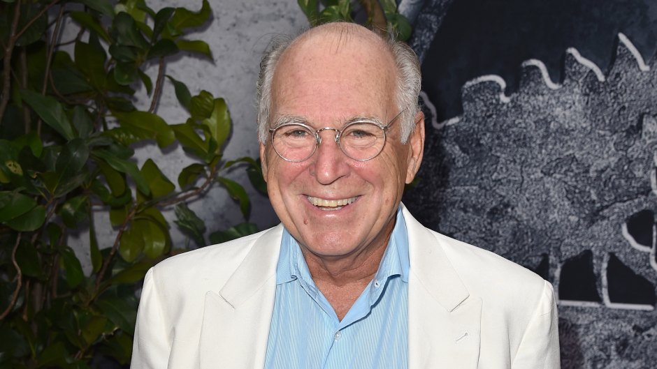 Jimmy Buffett wears white suit jacket and power blue shirt with glasses