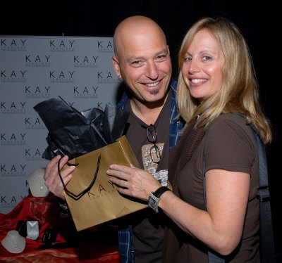 Howie Mandel and wife Terry smile while holding a gift bag