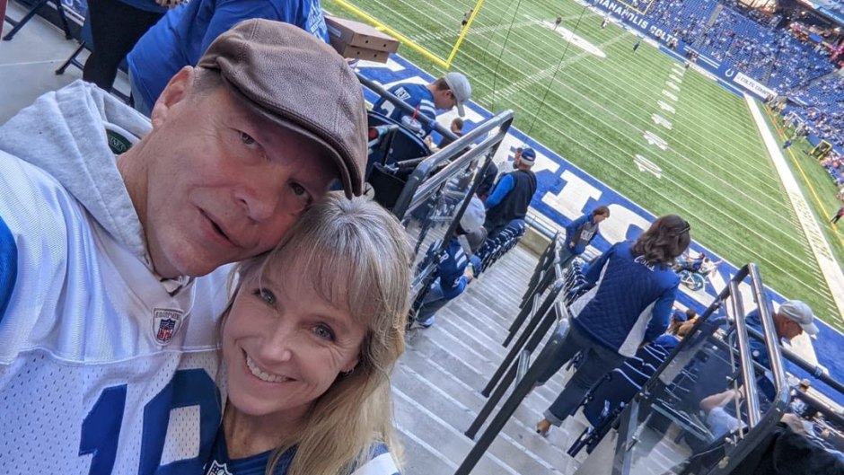 Karen E. Laine and husband Roger pose in football jerseys at stadium
