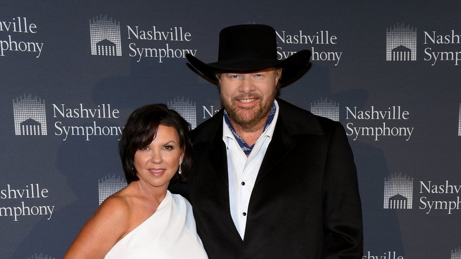 Toby Keith wears black suit and cowboy hat next to wife Tricia