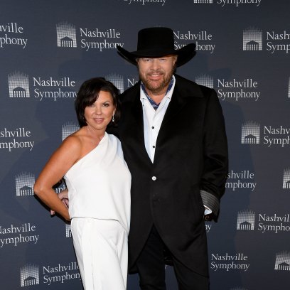 Toby Keith wears black suit and cowboy hat next to wife Tricia
