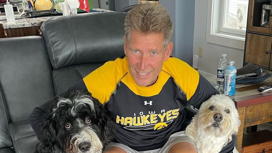 Gerry Turner sits on couch with his two dogs