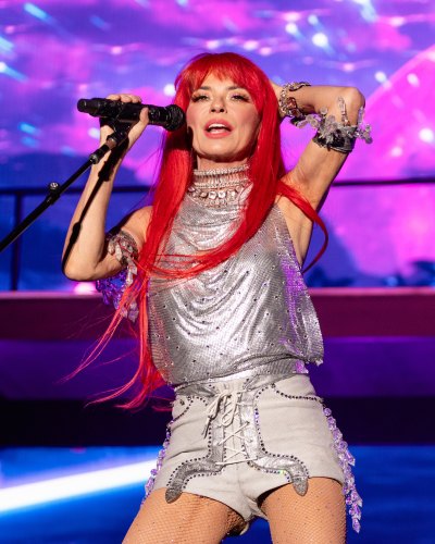 Shania Twain performs in a red wig and a silver outfit