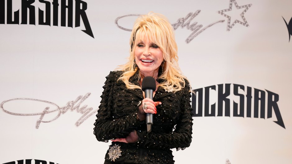 Dolly Parton holds microphone in black leather outfit
