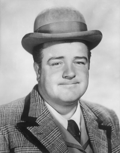 Lou Costello smiles while wearing a top hat