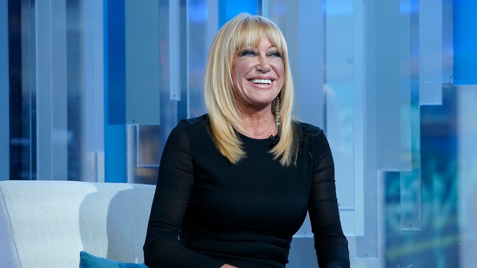 Suzanne Somers sits in a chair in a black outfit