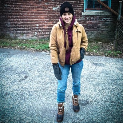 Mina Starsiak Hawk wears winter coat and knit hat and boots
