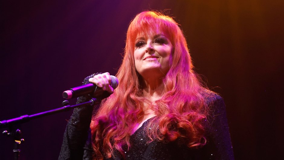 Wynonna Judd sings on stage in black outfit