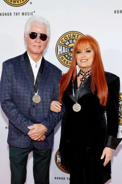 Larry Strickland and Wynonna Judd pose arm in arm on red carpet