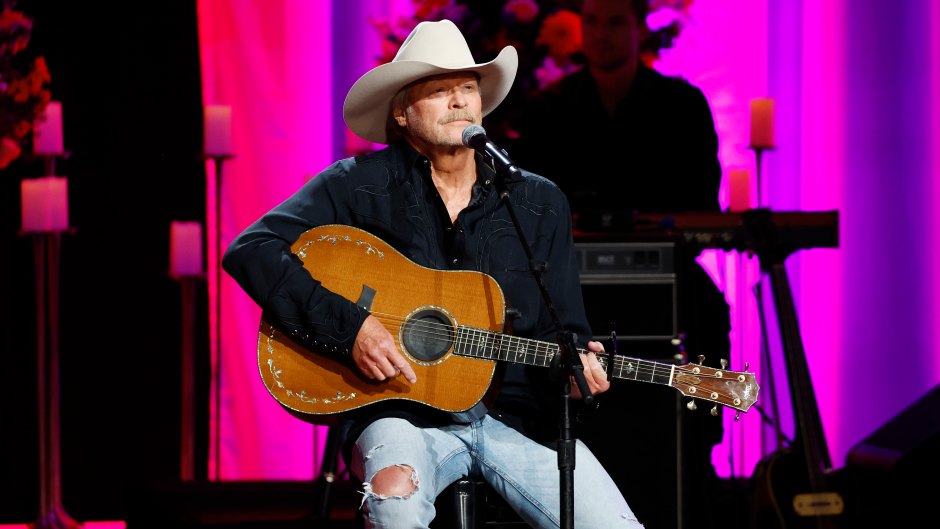 Alan Jackson sits on stage with his guitar