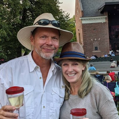 Karen E. Laine and Roger Rominger hold drinks while attending concert