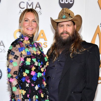Chris Stapleton in a suit next to wife Morgane in a colorful dress