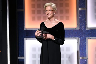 Annette Bening stands on stage in a black dress
