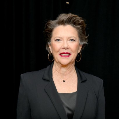 Annette Bening wears black blazer and black top with red lipstick