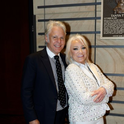 Tanya Tucker poses with her arms crossed in front of boyfriend Craig Dillingham
