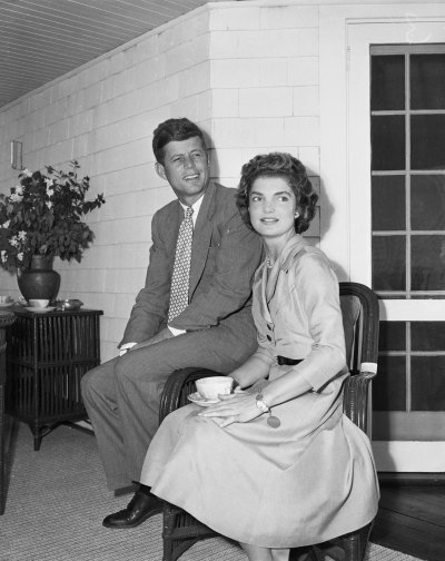 John F. Kenned and Jackie Kennedy sit side by side in chairs
