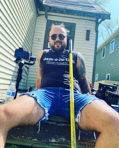 Tad Starsiak sits on porch in jean shorts 
